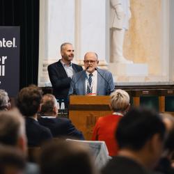 Person behind a podium, giving a presentation