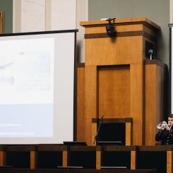 Person playing a trumpet next to a presentation screen