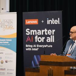 Person behind a podium, giving a presentation