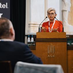 Person behind a podium, giving a presentation