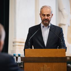 Person behind a podium, giving a presentation