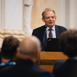 Person behind a podium, giving a presentation