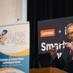 Person behind a podium, giving a presentation