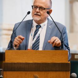 Person behind a podium, giving a presentation
