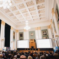 People in an auditorium, listening to a presentation