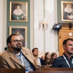 People in an auditorium, listening to a presentation