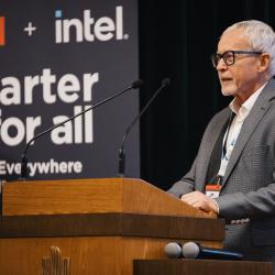 Person behind a podium, giving a presentation