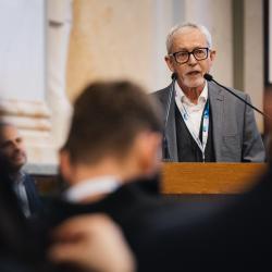Person behind a podium, giving a presentation