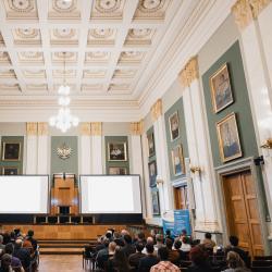 People in an auditorium, listening to a presentation