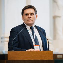 Person behind a podium, giving a presentation