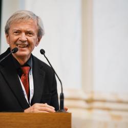 Person behind a podium, giving a presentation