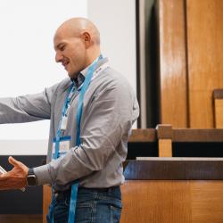 Person holding a painting, in an auditorium