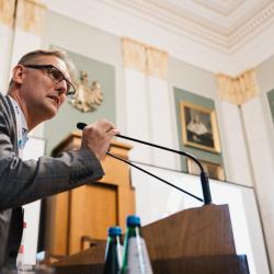 Person behind a podium, giving a presentation