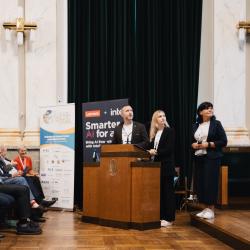 People behind a podium, giving a presentation