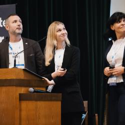 People behind a podium, giving a presentation