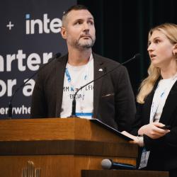 People behind a podium, giving a presentation