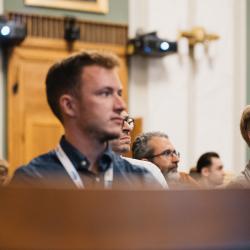 People in an auditorium, listening to a presentation