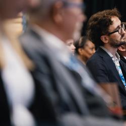 People in an auditorium, listening to a presentation