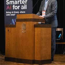 Person behind a podium, giving a presentation