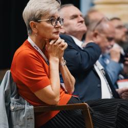 People in an auditorium, listening to a presentation