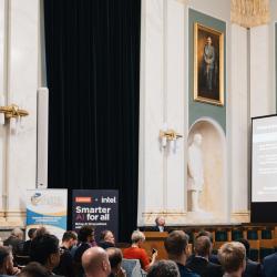 People in an auditorium, listening to a presentation