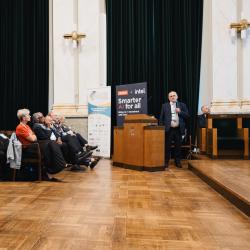 People in an auditorium, listening to a presentation