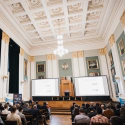 People in an auditorium, listening to a presentation