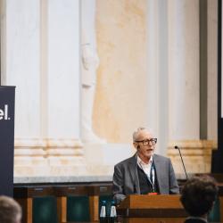 Person behind a podium, giving a presentation