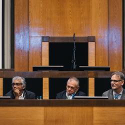 People behind a podium, listening to a presentation