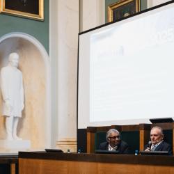 People behind a podium, giving a presentation