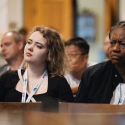 People in an auditorium, listening to a presentation