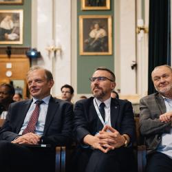People in an auditorium, listening to a presentation