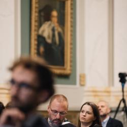 People in an auditorium, listening to a presentation
