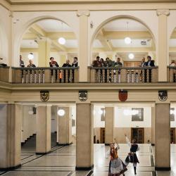 Music band with dancers in a building hall, people listening from the second floor