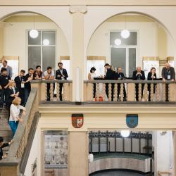 People in a building hall, looking down from the second floor