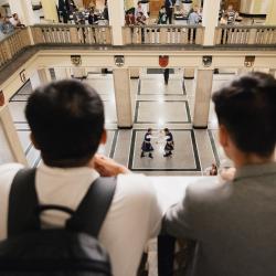 People in a building hall, looking down from the second floor