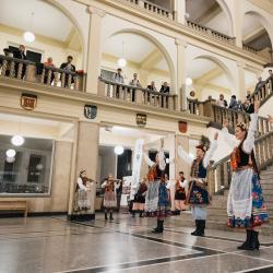 Music band with dancers in a building hall, people listening from the second floor