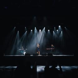 Music band on a dark stage, lit up by stage lights