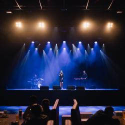 Music band on a dark stage, lit up by stage lights
