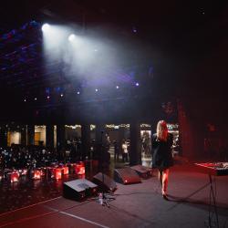 Singer on a dark stage, lit up by stage lights
