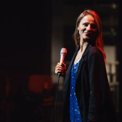 Singer on a dark stage, lit up by stage lights