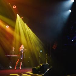 Singer on a dark stage, lit up by stage lights