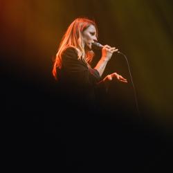 Singer on a dark stage, lit up by stage lights