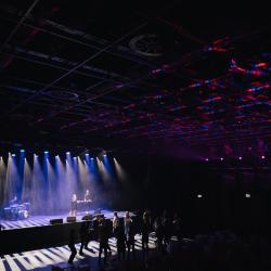 Music band on a dark stage, lit up by stage lights