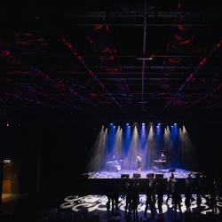 Music band on a dark stage, lit up by stage lights