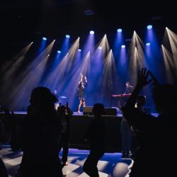 Music band on a dark stage, lit up by stage lights