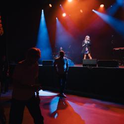 Music band on a dark stage, lit up by stage lights