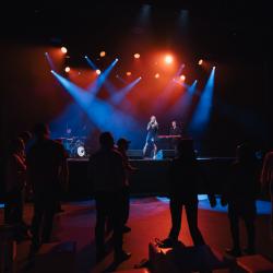 Music band on a dark stage, lit up by stage lights