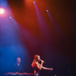Singer on a dark stage, lit up by stage lights
