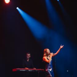 Singer on a dark stage, lit up by stage lights